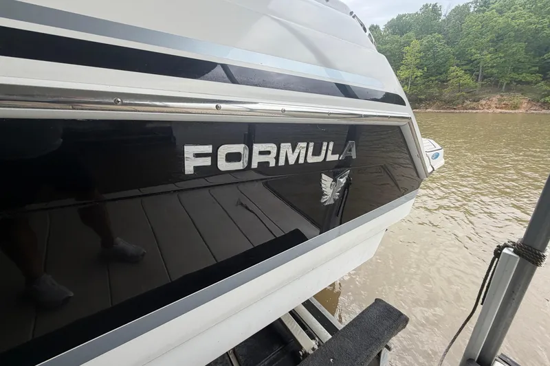Slide: The Image of 2005 Formula 330 Sun Sport boat docked by a lake with wooded shoreline. - 5