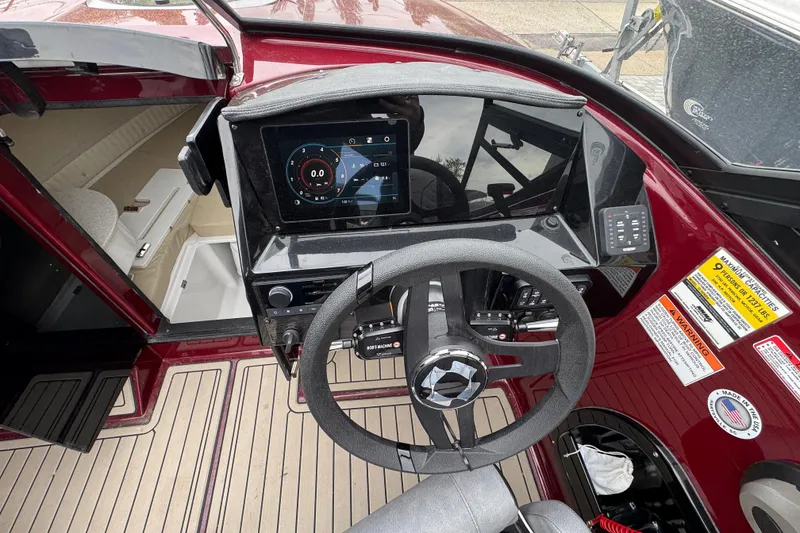Slide: The Image of 2026 Stingray 23 OCX boat dashboard with steering wheel and digital display. - 16