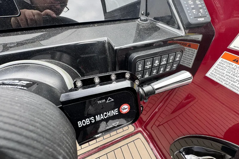 Slide: The Image of Control panel of 2026 Stingray 23 OCX boat with trim lever and warning labels. - 20