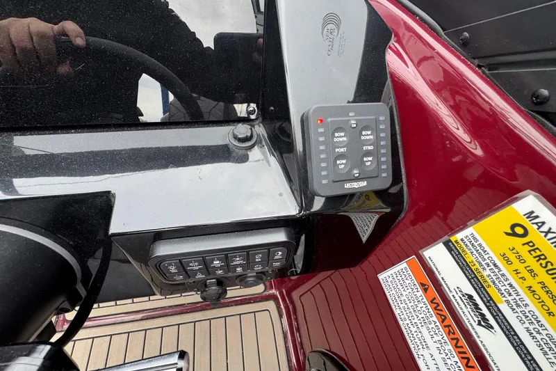 Slide: The Image of Control panel of 2026 Stingray 23 OCX boat with warning labels and steering wheel. - 21