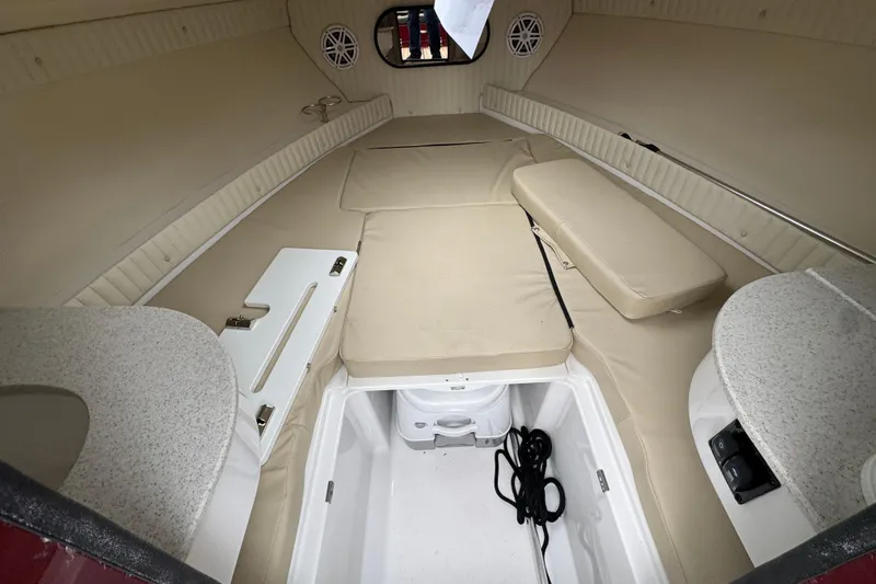 Slide: The Image of Interior cabin of 2026 Stingray 23 OCX boat with beige seating and storage. - 25