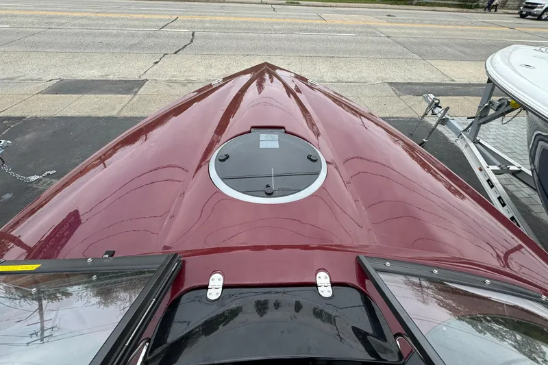 Slide: The Image of 2026 Stingray 23 OCX boat with sleek maroon finish, viewed from the bow. - 26