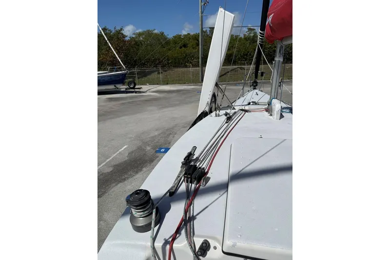Slide: The Image of 1990 Corsair F 27 sailboat deck with rigging and winch, parked on pavement. - 10
