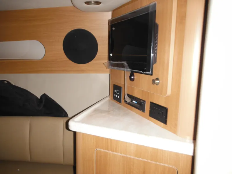 Slide: The Image of Interior of 2014 Rinker 290 Express Cruiser with TV and wood paneling. - 21