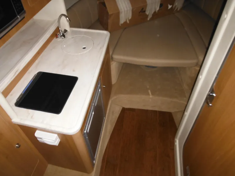 Slide: The Image of Interior of 2014 Rinker 290 Express Cruiser with kitchenette and sleeping area. - 25