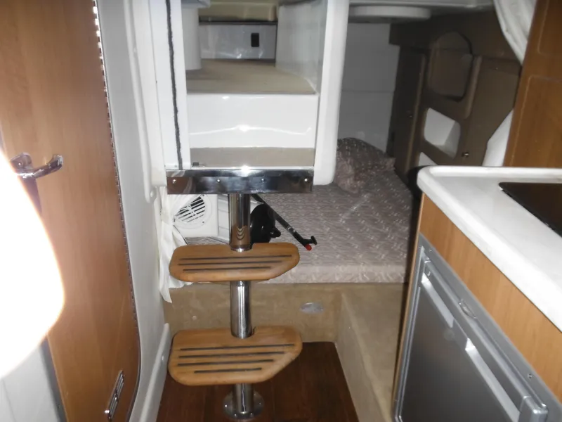 Slide: The Image of Interior of 2014 Rinker 290 Express Cruiser with sleeping area and stairs. - 26