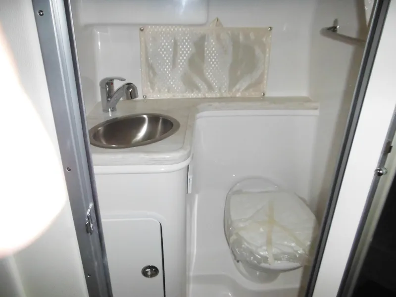 Slide: The Image of 2014 Rinker 290 Express Cruiser bathroom with sink and toilet. - 27