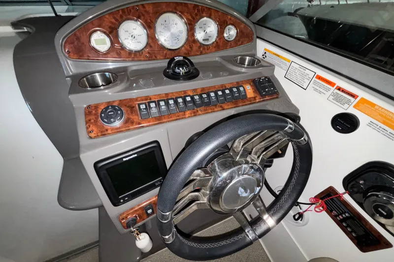 Slide: The Image of 2014 Rinker 290 Express Cruiser dashboard with steering wheel and control panel. - 32