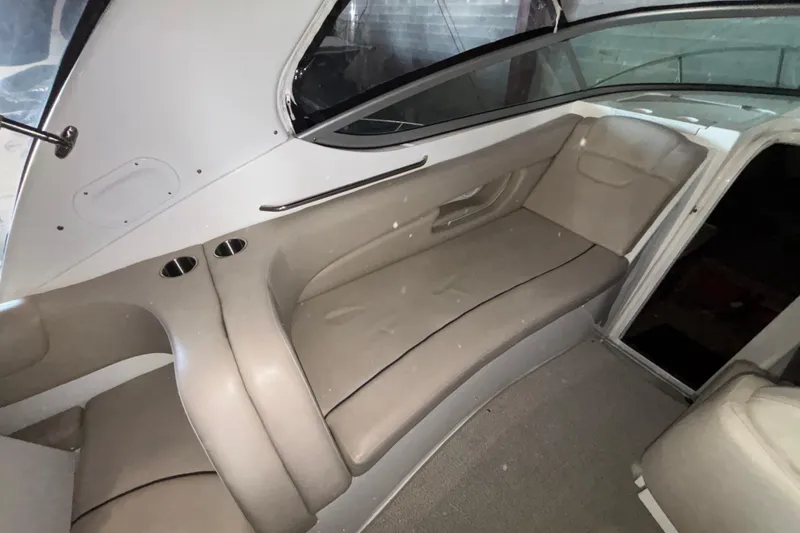 Slide: The Image of Interior of a 2014 Rinker 290 Express Cruiser with beige seating and cup holders. - 33