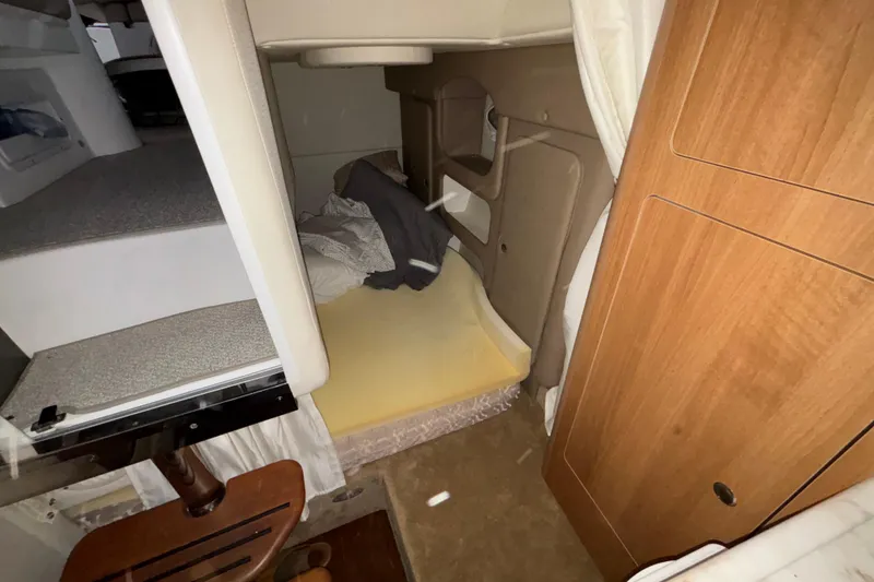 Slide: The Image of 2014 Rinker 290 Express Cruiser cabin interior with bed and wooden cabinetry. - 36