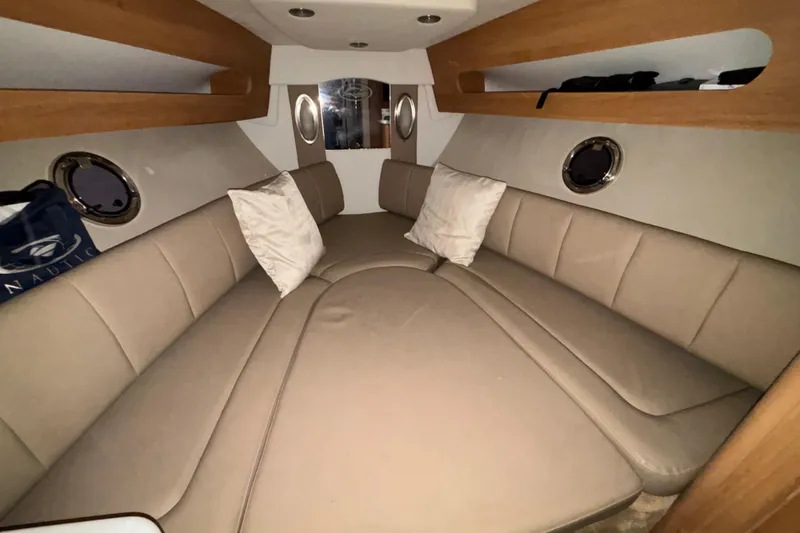 Slide: The Image of Interior cabin of 2014 Rinker 290 Express Cruiser with beige seating and pillows. - 37