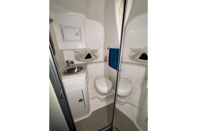 Slide: The Image of 2014 Rinker 290 Express Cruiser bathroom with sink, toilet, and mirror. - 42