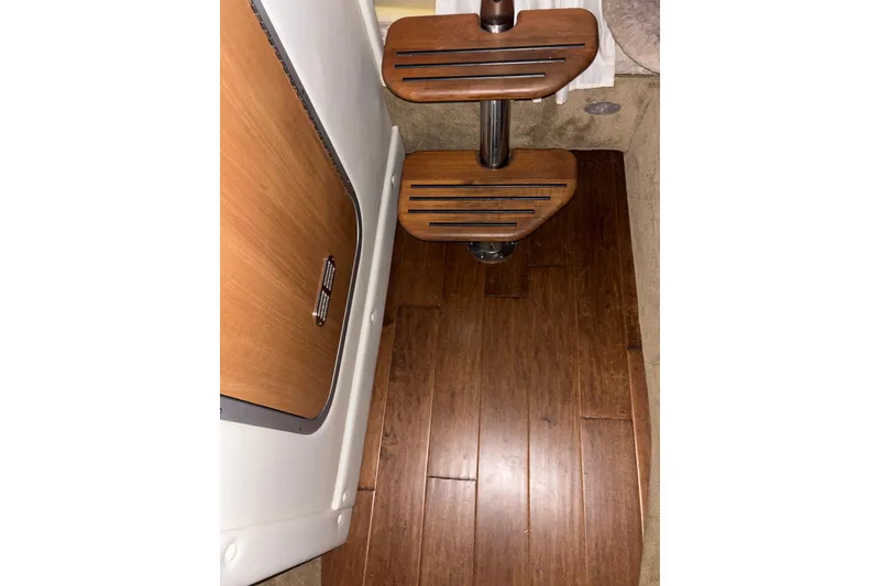 Slide: The Image of Wooden steps and flooring inside a 2014 Rinker 290 Express Cruiser boat. - 44