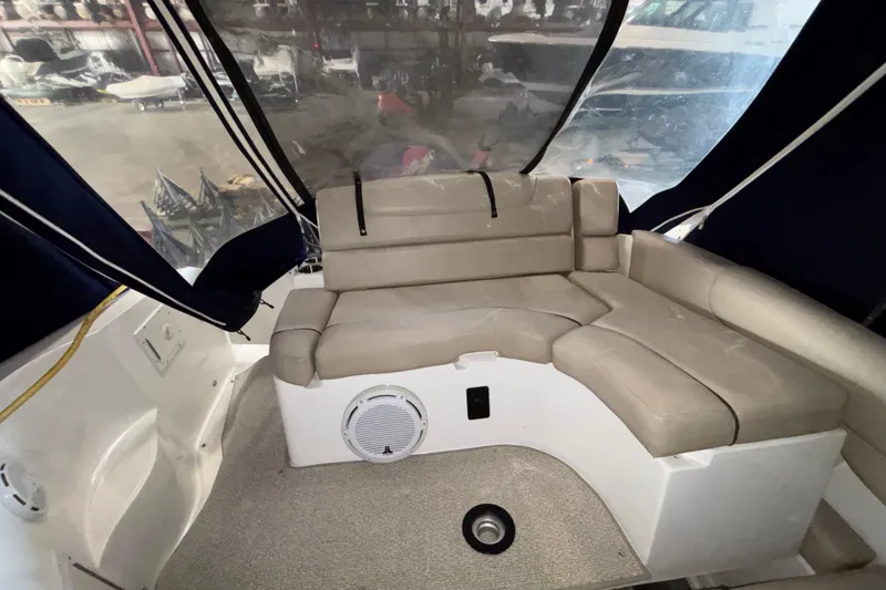Slide: The Image of 2014 Rinker 290 Express Cruiser interior with beige seating and blue canopy. - 45