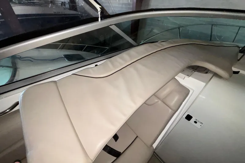 Slide: The Image of 2014 Rinker 290 Express Cruiser interior with beige seating and protective cover. - 46