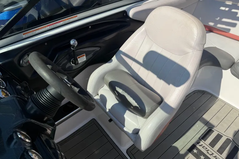 Slide: The Image of 2005 MasterCraft XStar boat interior with steering wheel and white captain's seat. - 11