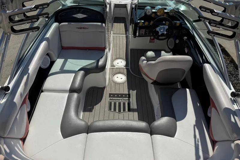 Slide: The Image of 2005 MasterCraft XStar boat interior with gray seating and modern dashboard. - 23