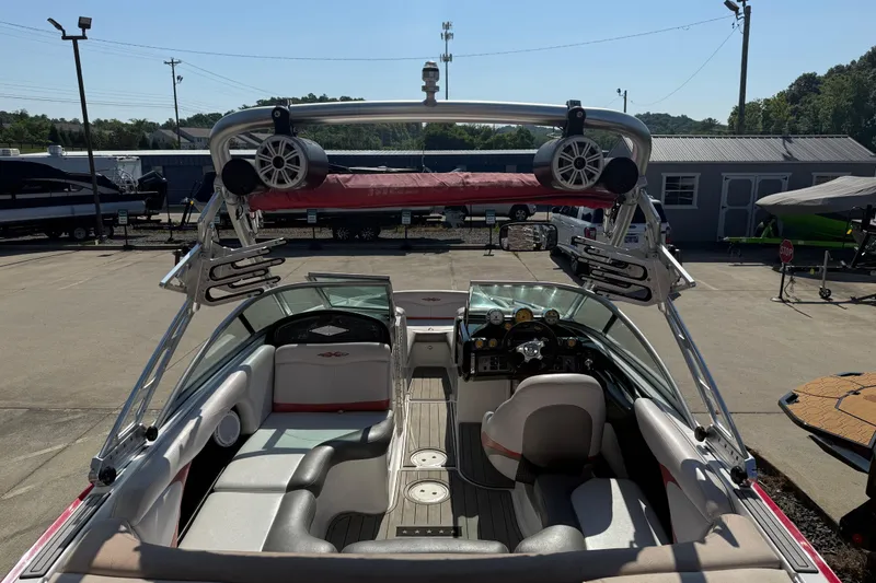 Slide: The Image of 2005 MasterCraft XStar boat interior with speakers and seating, parked in a marina. - 25