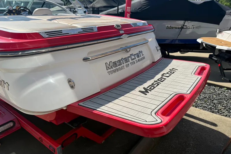 Slide: The Image of 2005 MasterCraft XStar boat with red and white detailing, rear view. - 30