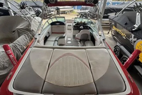 Slide: The Image of 2005 MasterCraft XStar boat interior with seating and dashboard, stored in a covered area. - 7