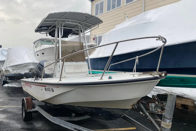 The Image of 1994 Boston Whaler 19 OUTRAGE boat on trailer, parked near covered vessels. - 1
