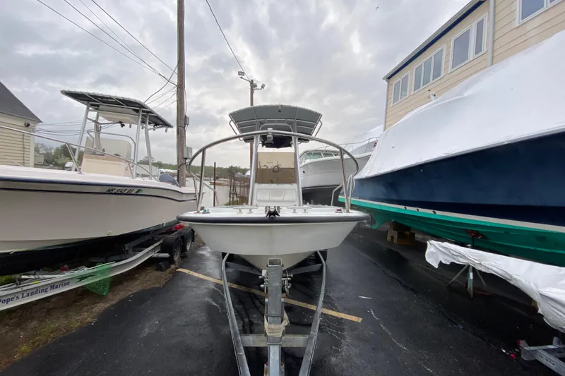 Slide: The Image of 1994 Boston Whaler 19 OUTRAGE boat on trailer, parked between other boats. - 4