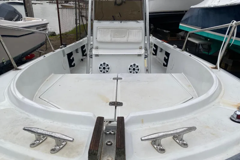 Slide: The Image of 1994 Boston Whaler 19 OUTRAGE boat interior with seating and speakers, docked near other boats. - 5