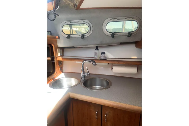 Slide: The Image of 1991 Bayliner 3288 Motoryacht kitchen with dual sinks and porthole windows. - 10