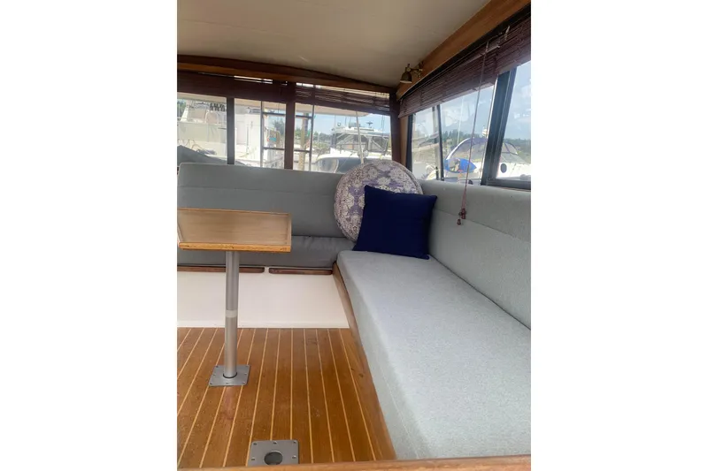 Slide: The Image of Interior of 1991 Bayliner 3288 Motoryacht with gray seating and wooden table. - 11