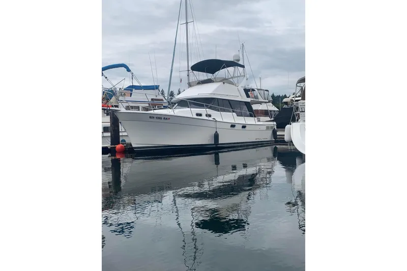Slide: The Image of 1991 Bayliner 3288 Motoryacht docked in a marina, reflecting on calm water. - 2