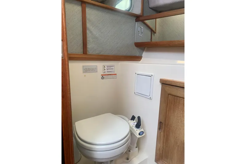 Slide: The Image of 1991 Bayliner 3288 Motoryacht bathroom with toilet and wooden cabinetry. - 6
