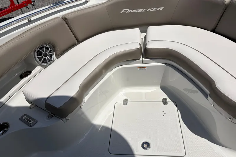 Slide: The Image of 2026 Crownline 210 CC Finseeker boat interior with cushioned seating and speaker. - 16