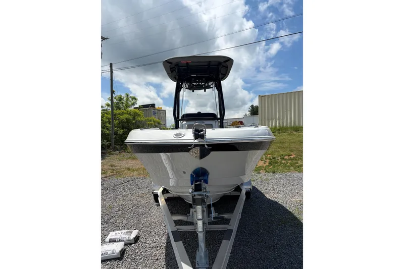 Slide: The Image of 2026 Crownline 210 CC Finseeker boat on trailer under a partly cloudy sky. - 19
