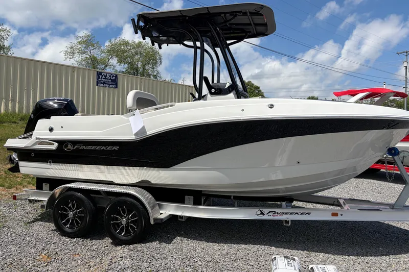Slide: The Image of 2026 Crownline 210 CC Finseeker boat on trailer, displayed outdoors under a clear sky. - 2