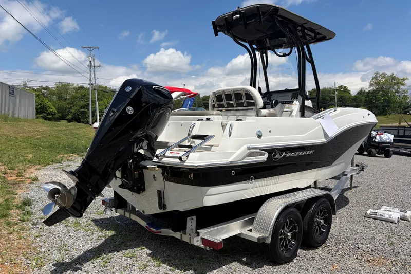 Slide: The Image of 2026 Crownline 210 CC Finseeker boat on trailer, parked outdoors under blue sky. - 3