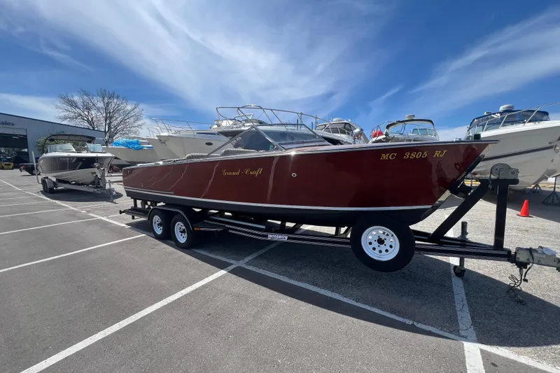 The Image of 1997 Grand Craft 24 Luxury Sport boat on trailer in parking lot. - 1