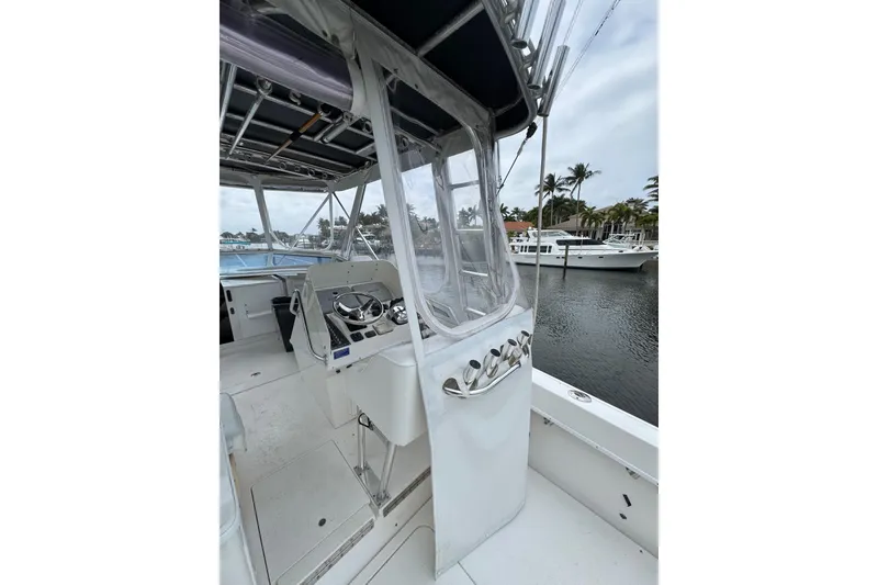 Slide: The Image of 2008 Contender 35 Express Side Console boat interior with helm, docked by waterfront homes. - 10