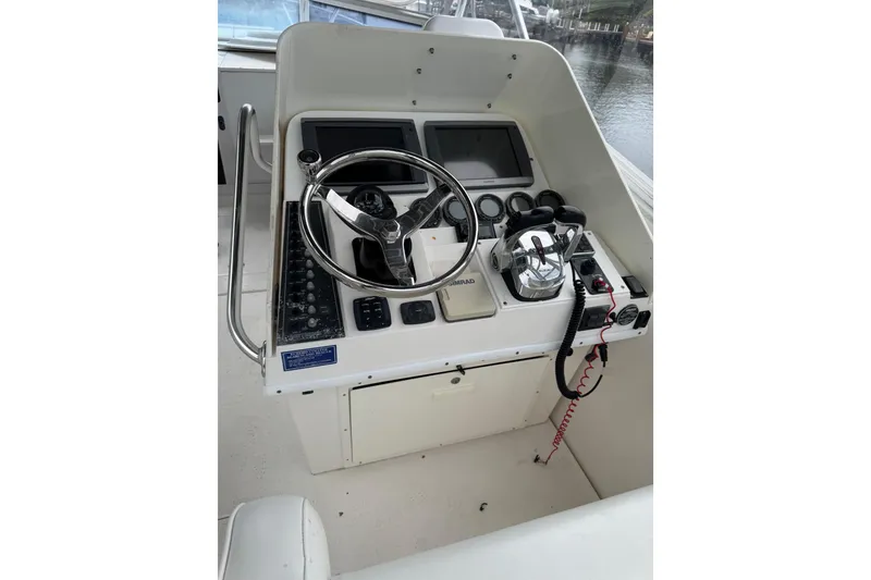 Slide: The Image of 2008 Contender 35 Express Side Console boat helm with steering wheel and controls. - 11