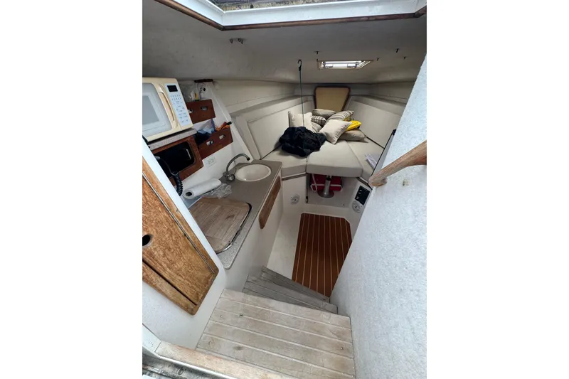Slide: The Image of 2008 Contender 35 Express Side Console cabin interior with kitchenette and seating area. - 12