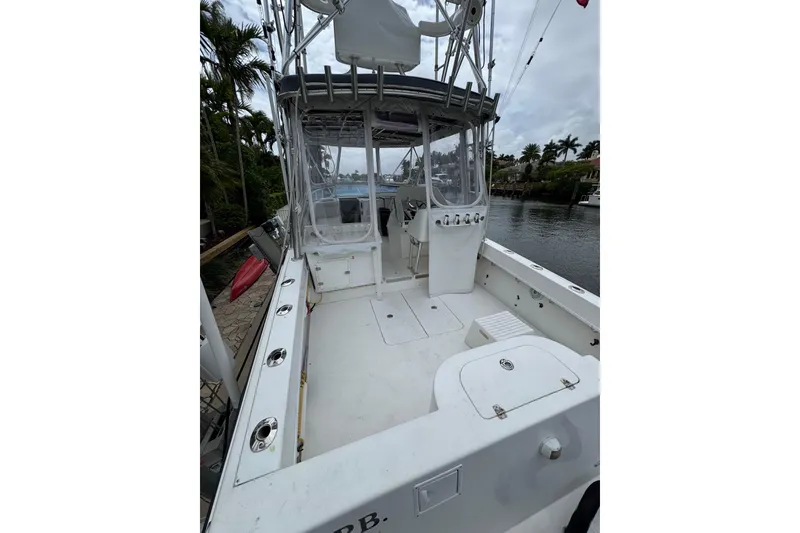 Slide: The Image of 2008 Contender 35 Express Side Console boat docked by a canal, featuring spacious deck. - 14