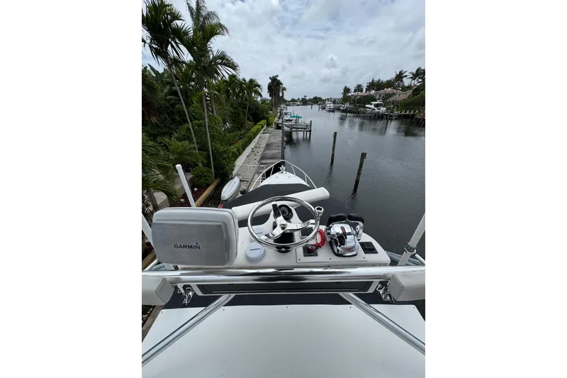 Slide: The Image of 2008 Contender 35 Express Side Console boat with Garmin navigation, docked by a canal. - 16