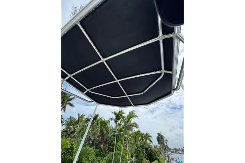 Slide: The Image of T-top canopy of 2008 Contender 35 Express Side Console boat with tropical background. - 17
