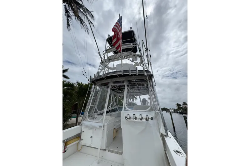 Slide: The Image of 2008 Contender 35 Express Side Console boat with American flag, docked under cloudy skies. - 21