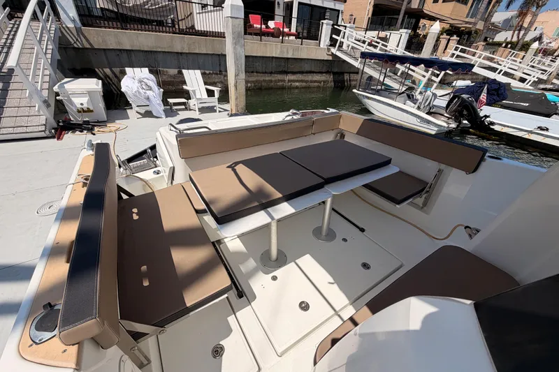 Slide: The Image of 2017 Jeanneau Merry Fisher 855 Marlin boat with spacious seating and table on deck. - 13