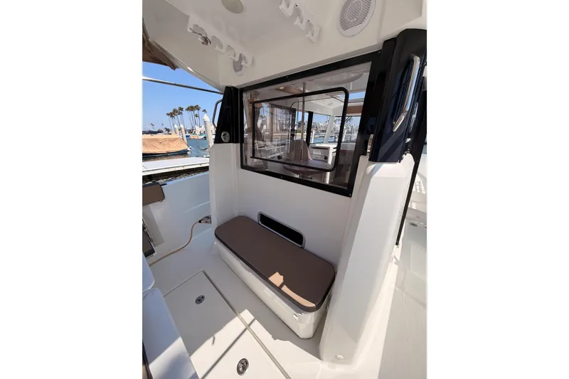 Slide: The Image of 2017 Jeanneau Merry Fisher 855 Marlin boat interior with seating and window view. - 18