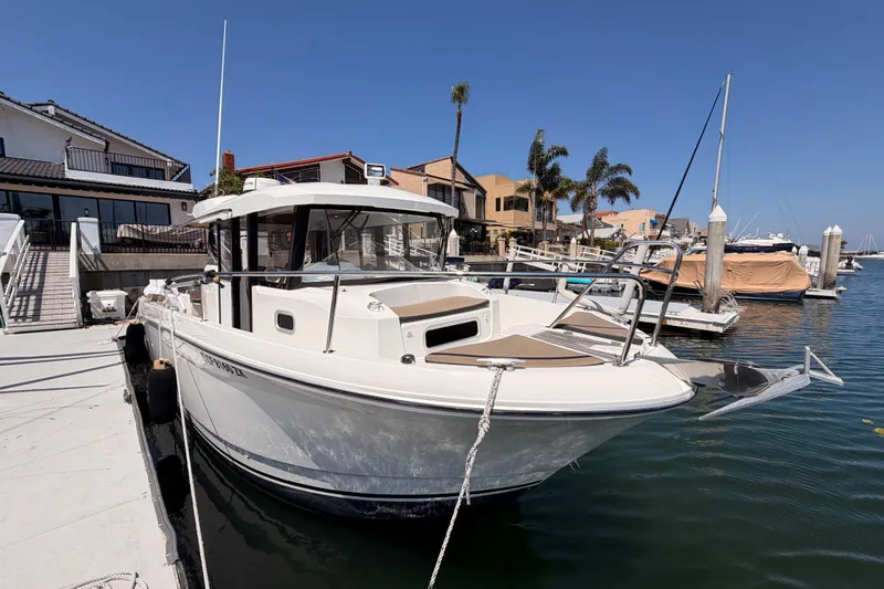 Slide: The Image of 2017 Jeanneau Merry Fisher 855 Marlin docked at marina under clear blue sky. - 2