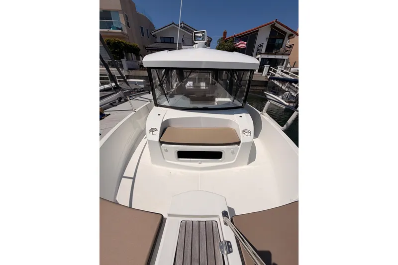 Slide: The Image of 2017 Jeanneau Merry Fisher 855 Marlin boat docked, showcasing front seating and cabin. - 26