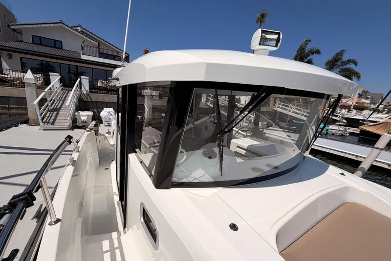 Slide: The Image of 2017 Jeanneau Merry Fisher 855 Marlin docked, showcasing sleek design and spacious deck. - 27
