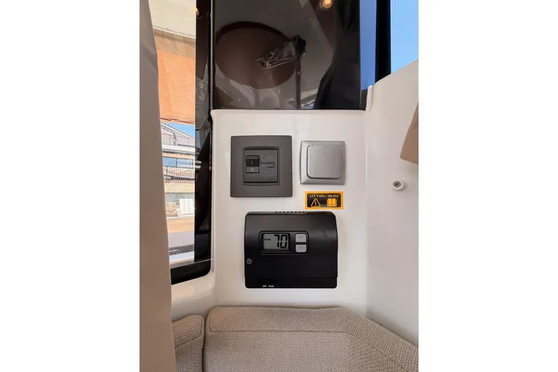 Slide: The Image of Control panel inside 2017 Jeanneau Merry Fisher 855 Marlin boat, featuring switches and digital display. - 33