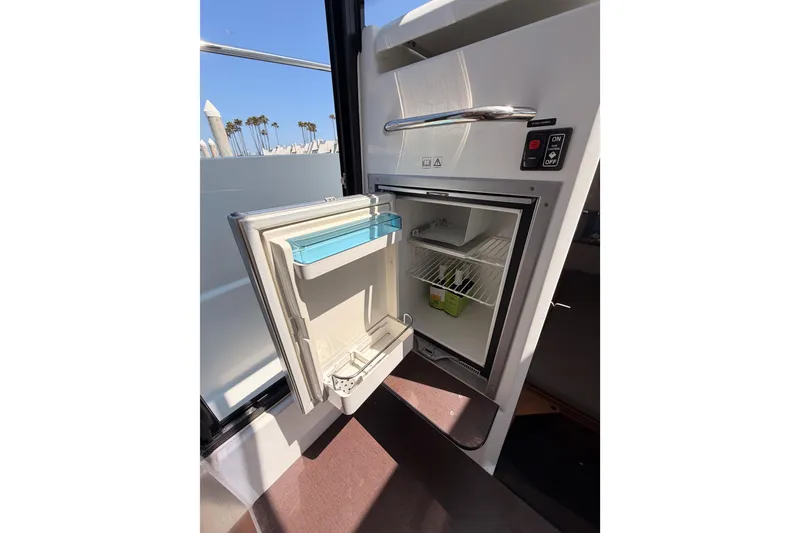 Slide: The Image of Open refrigerator on 2017 Jeanneau Merry Fisher 855 Marlin boat, showcasing interior storage. - 43